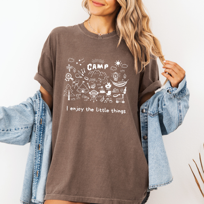 Espresso Comfort Colors graphic tee with a blue camp doodle illustration featuring outdoor icons and the phrase “I enjoy the little things”