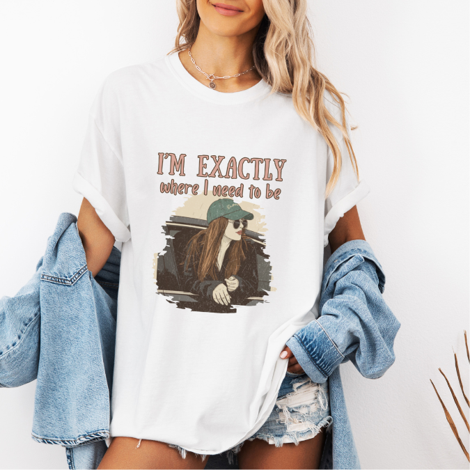 White Comfort Colors graphic tee with a vintage-style illustration of a woman leaning out of a car window and the phrase “I’m exactly where I need to be.”