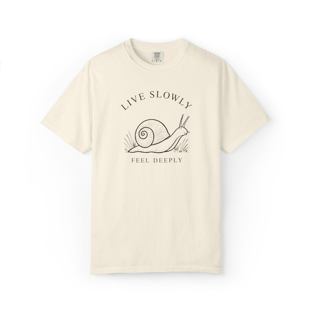 Front view of an ivory Comfort Colors t-shirt featuring the Live Slowly, Feel Deeply snail design