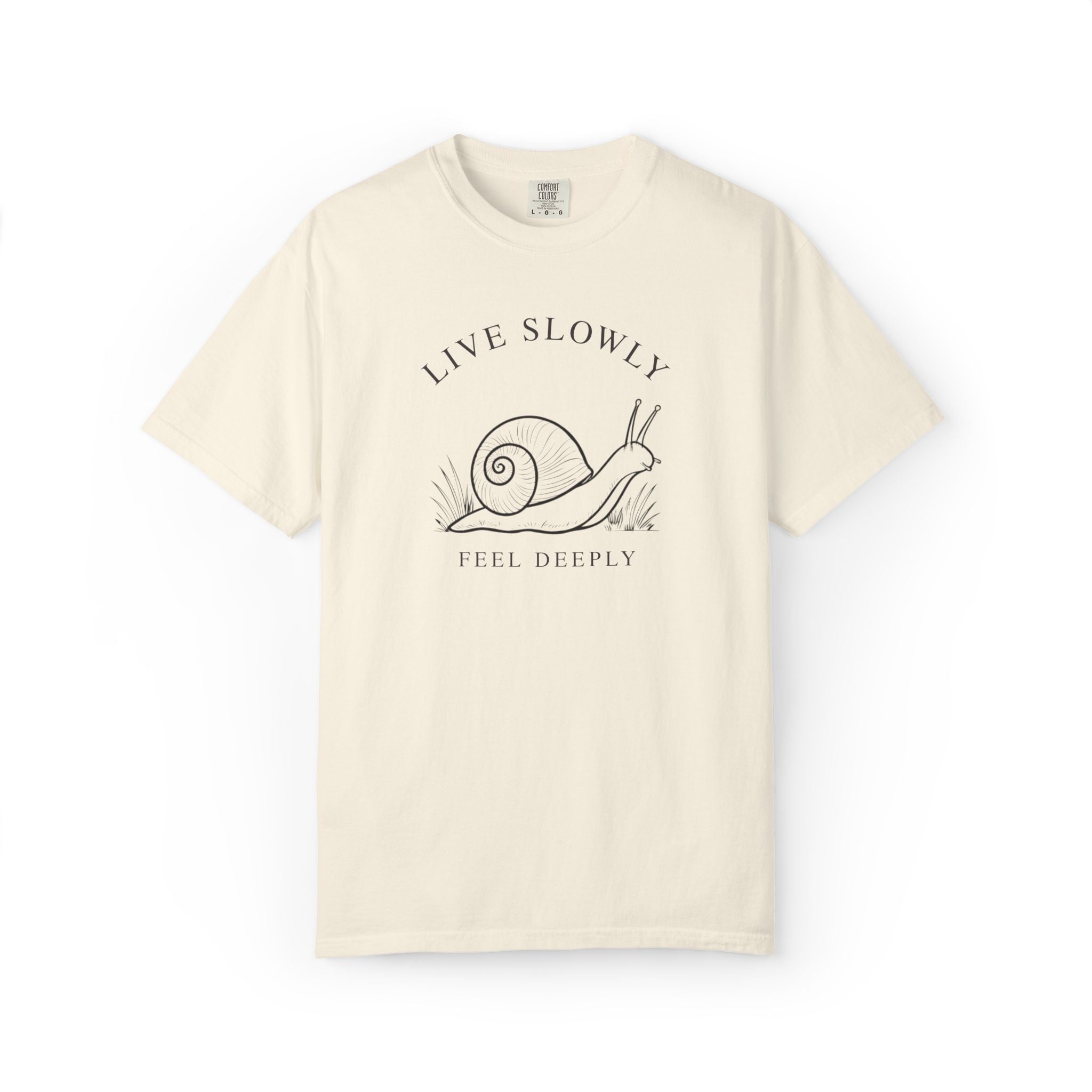 Front view of an ivory Comfort Colors t-shirt featuring the Live Slowly, Feel Deeply snail design