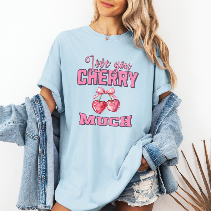 Light blue Comfort Colors graphic tee with pink lettering, heart-shaped cherries with a bow, and the phrase “Love You Cherry Much.”