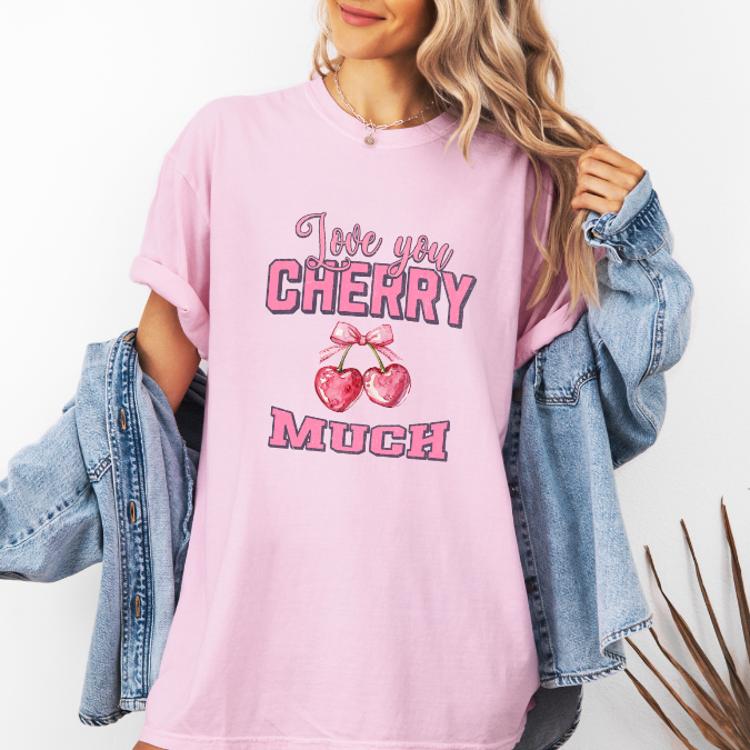 Pink Comfort Colors graphic tee with pink lettering, heart-shaped cherries with a bow, and the phrase “Love You Cherry Much.”