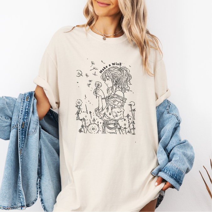 Ivory Comfort Colors graphic tee with a feminine line art illustration of a woman holding a dandelion and the phrase “Make a Wish”
