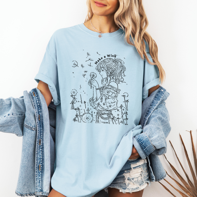 Light blue Comfort Colors graphic tee with a feminine line art illustration of a woman holding a dandelion and the phrase “Make a Wish”