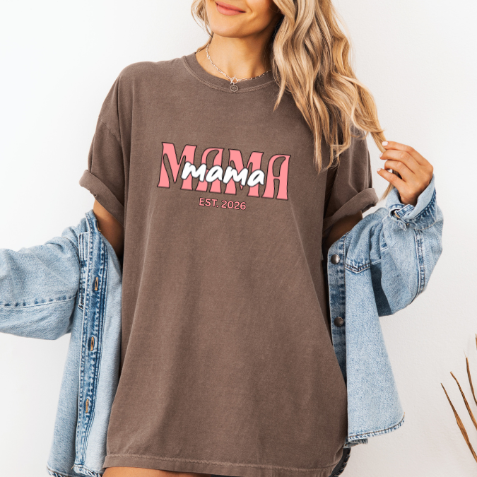 Espresso Comfort Colors t-shirt with layered pink MAMA text and a customizable EST. year design for new moms