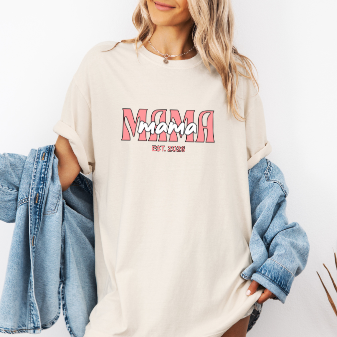Ivory Comfort Colors t-shirt with layered pink MAMA text and a customizable EST. year design for new moms