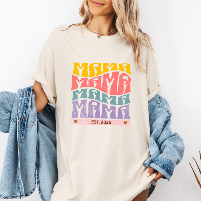 Ivory Comfort Colors t-shirt with bold retro stacked MAMA lettering in yellow, pink, teal, and purple plus a customizable EST. year design for new moms