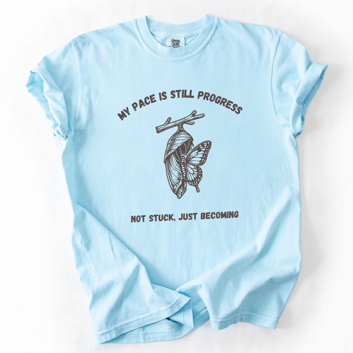 My Pace Is Still Progress chrysalis Comfort Colors tee in Chambray blue, flat lay product photo