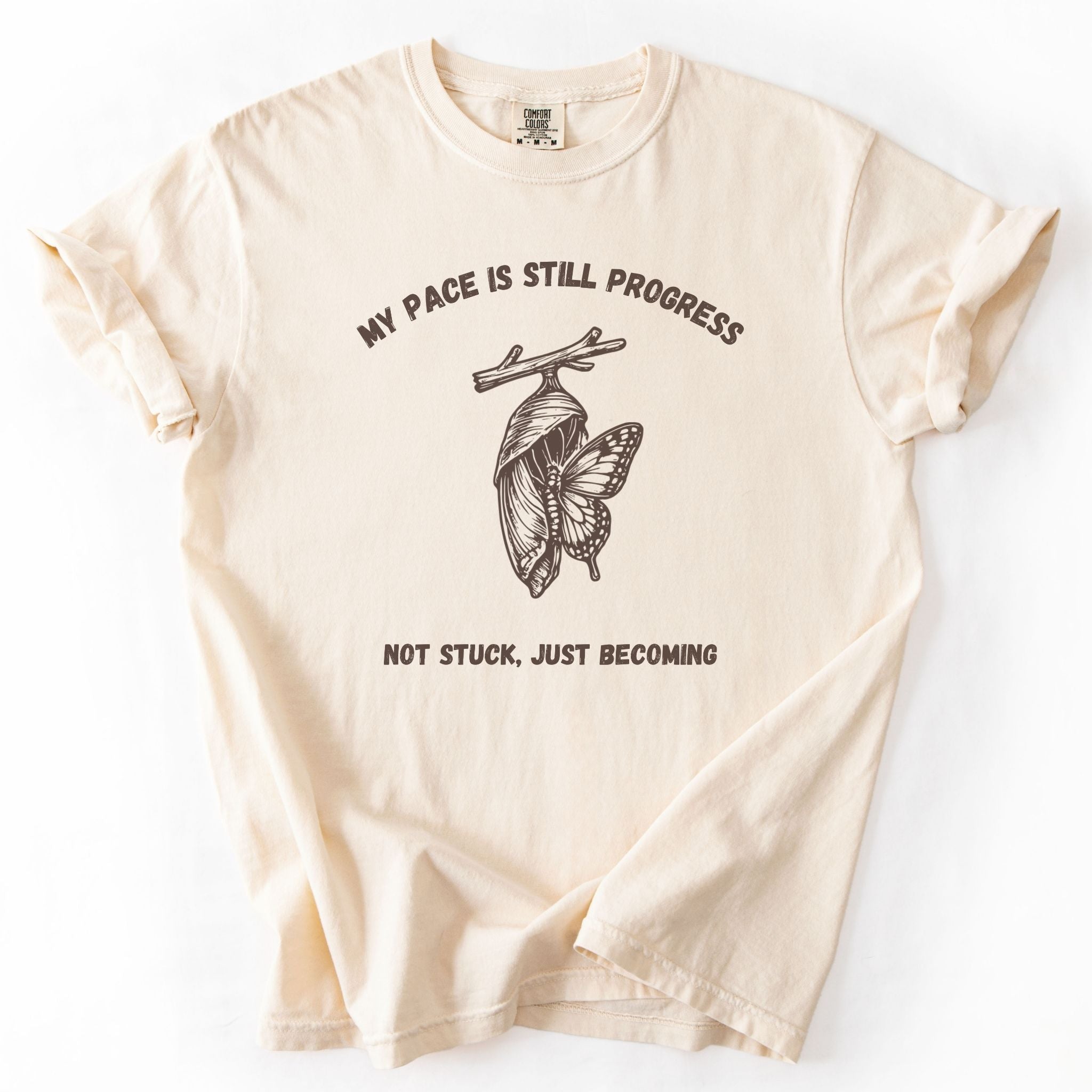 My Pace Is Still Progress chrysalis Comfort Colors tee in Ivory, flat lay product photo