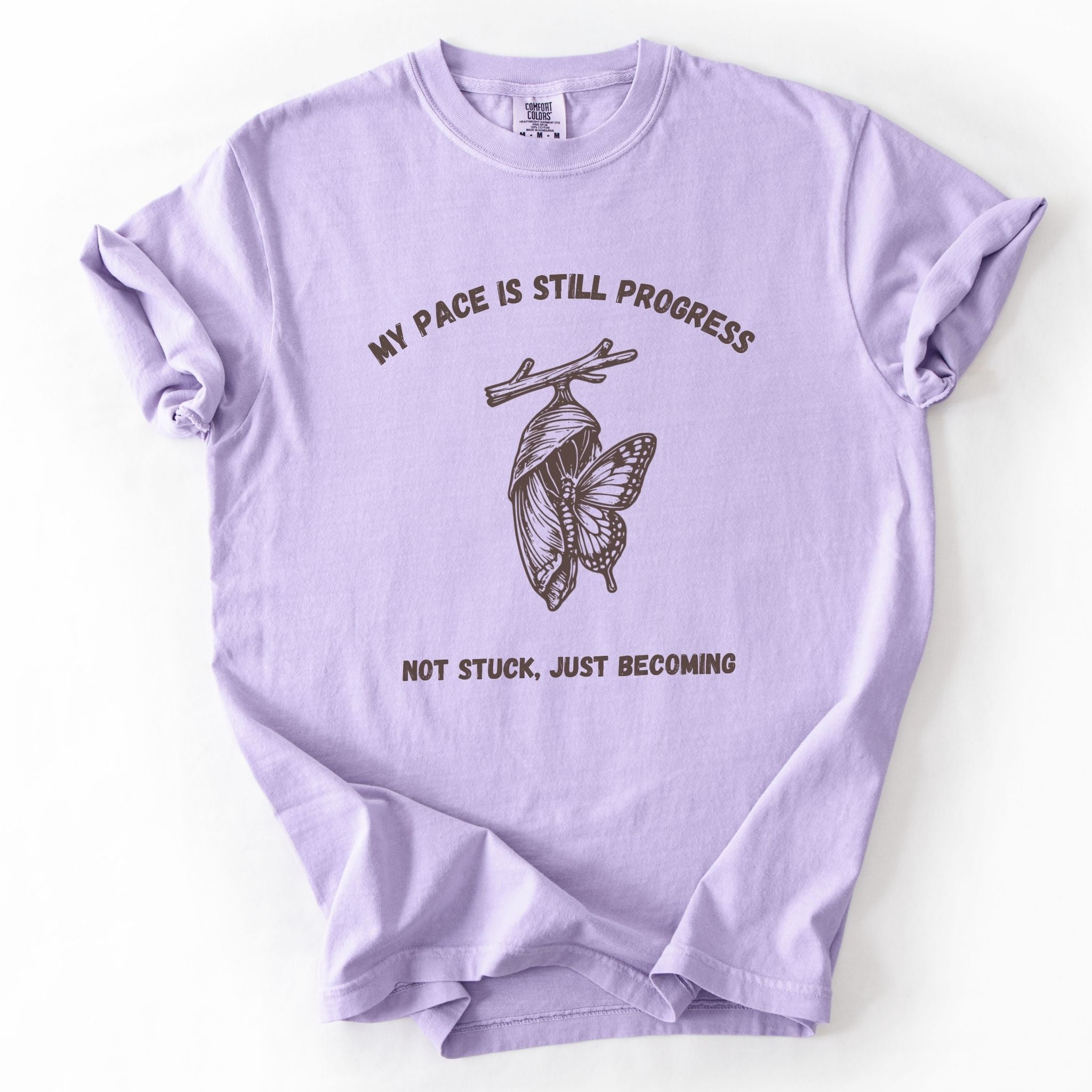My Pace Is Still Progress chrysalis Comfort Colors tee in Orchid lavender, flat lay product photo