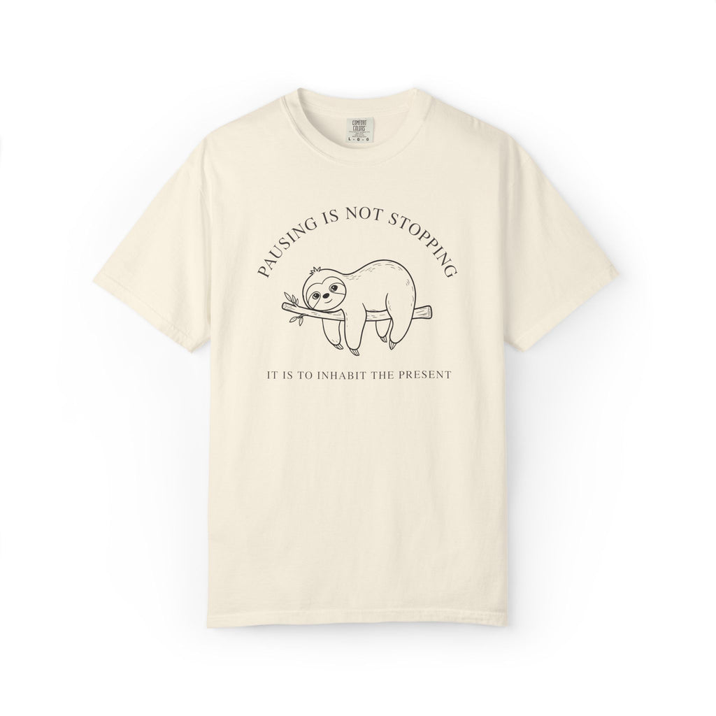 Front view of an ivory Comfort Colors t-shirt featuring the Pausing Is Not Stopping sloth design