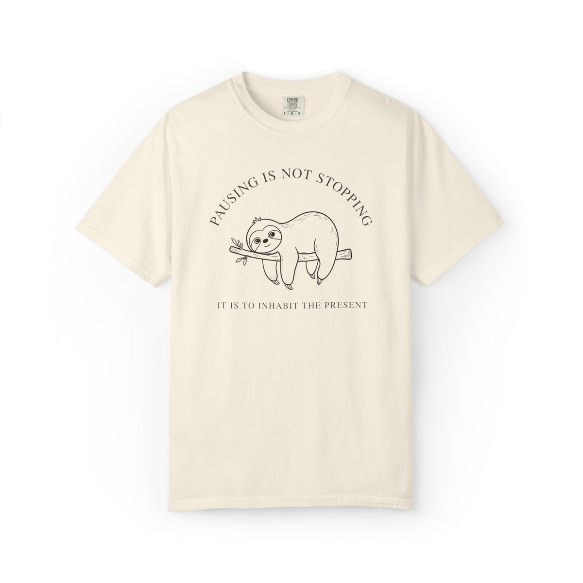 Front view of an ivory Comfort Colors t-shirt featuring the Pausing Is Not Stopping sloth design