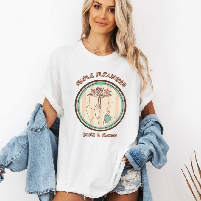 White Comfort Colors graphic tee with a circular Books & Blooms design featuring an open book with flowers growing from it and a cup of coffee.