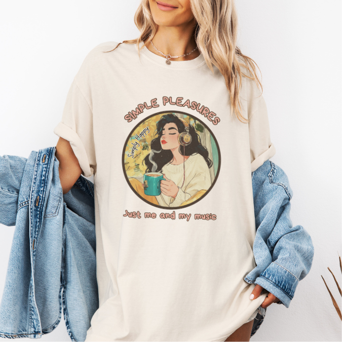 Ivory Comfort Colors graphic tee with a circular design of a woman wearing headphones, holding a warm drink, and the phrase “Just me and my music.”